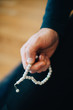 © Alder - Cropped image of mature man with prayer beads at home