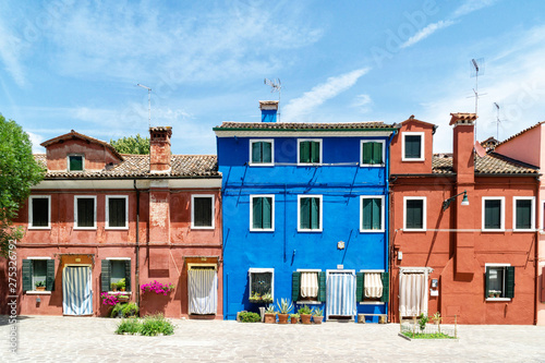 A House Front In Bold Colors With Striped Curtains For Sun