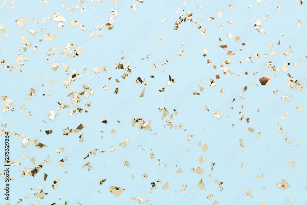 Golden foil confetti on light blue background. Festive, party or holiday glowing backdrop. Flat lay, top view. - obrazy, fototapety, plakaty 