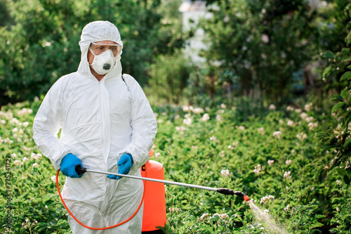 Fotomural Worker sprays organic pesticides on plants
