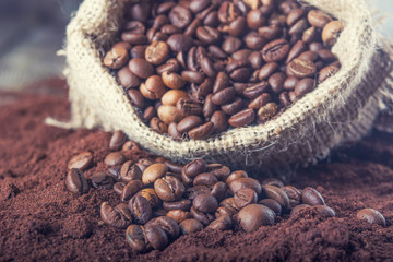 Wall Mural - Brown beans with burlap bag  and ground coffee on the wooden table. Rustic atmosphere. Advertising concept.