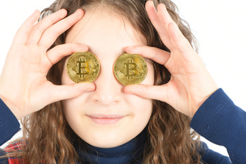 Happy girl with long curly hair keeps the eye instead two silver cryptocurrency bitcoin in hands on white background.