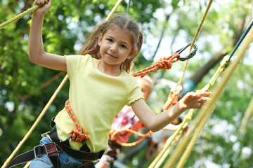 Poster - Little girl climbing in adventure park. Summer camp