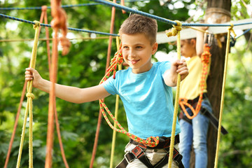 Poster - Little boy climbing in adventure park. Summer camp