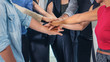 © Mongkolchon - business people stacking hands together to cheer up team spirit