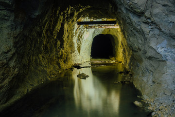 Canvas Print - Dark creepy dirty flooded abandoned mine tunnel