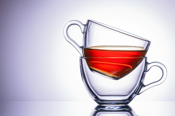 Two transparent mugs of tea. location on the right, close-up.