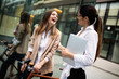 © NDABCREATIVITY - Happy business colleagues talking and walking in the city outdoor