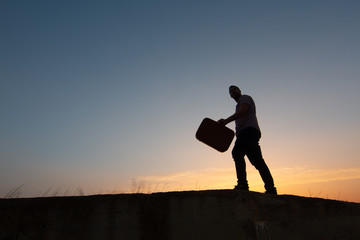 Sticker - silhouette of man with suitcase at sunrise