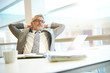 © goodluz - Content businessman leaning back on chair in office