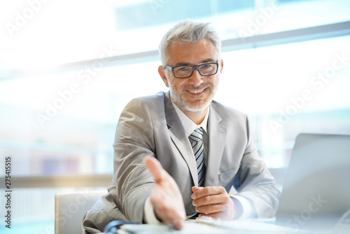 Fotomural Portrait of mature businessman sitting in office looking at camera