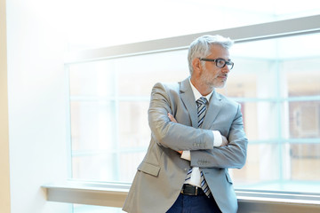 Wall Mural - Mature business man looking out office window