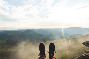 feet selfie sport shoes traveler relaxing on cliff mountains clouds outdoor with aerial view mountai