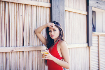 Sexy woman in bikini drinking cocktail in summer and enjoying her vacation