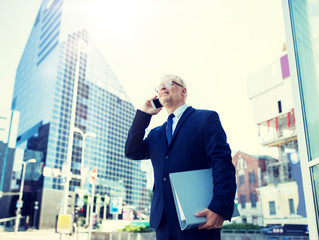 Canvas Print - business, technology, communication and people concept - senior businessman with document folder calling on smartphone in city