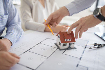 Poster - architecture, construction business and people concept - close up of architects with blueprint discussing house project at office