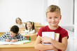 © serhiibobyk - Schoolboy holding books, looking at camera, smiling.