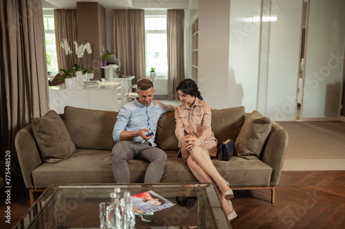 Husband And Wife Sitting On Sofa Waiting For Plastic