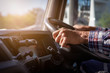 © KM.Photo - Truck driver keeps driving with one hands and change gears,The man Behind Semi Truck Steering Wheel,spot focus.