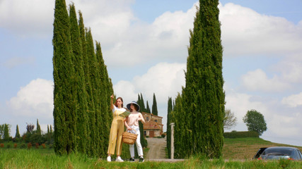 Two young women stand by the road look at the map