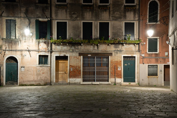 Wall Mural - Night photography of typical houses with doors and windows in Venice, Italy. Magical atmosphere of lights at night.