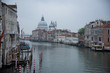 Grand Canal and the island of Santa Maria della Salute with the Dogana from the Accademia bridge in Venice, Italy. Widespread dawn light over the lagoon with a view of the houses and the ferry stop.