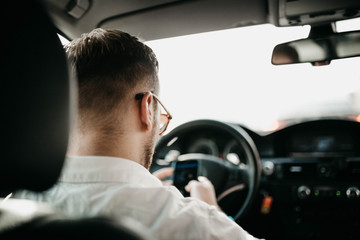 Wall Mural - driver businessman rides a business class car through the city in sunglasses. luxury taxi services.