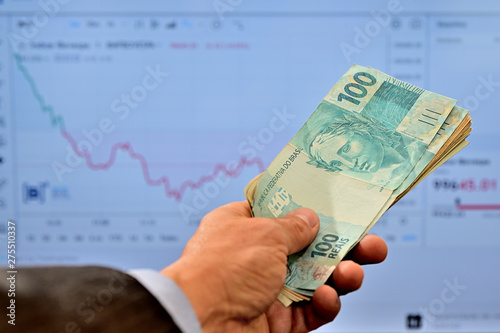 Cuadros en Lienzo Dinheiro na mão de homem comprando ações no mercado de valores