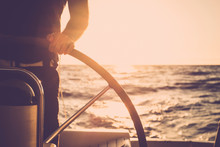 Close Up Of Man's Hand On Sail Boat Helm - Marine Ship Lifestyle Concept Of Travel For Beautiful Holiday Destination - Alternative People Life - Sunset And Sunlight In Background On The Ocean