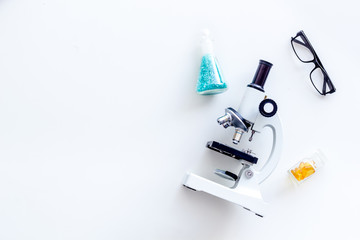 Desk of doctor in laboratory with microscope, test tube for medical research on white background top view space for text