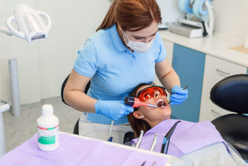 Dentist working with patient in modern clinic. Modern equipment in medicine. Teeth Care concept.