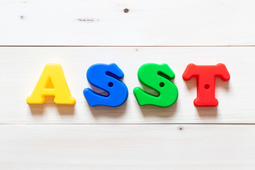 Poster - Letter block in word asst (abbreviation of assistant) on white wood background