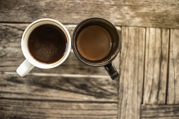 Top view of 2 coffee cups placed close together on the table in a coffee shop.Business and Heavy work concept.