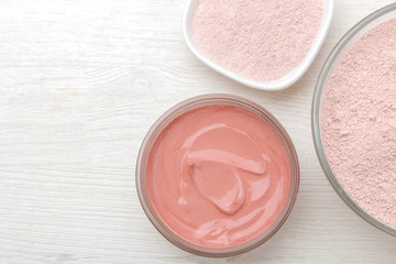 Cosmetic clay. Pink cosmetic clay in different types on a white wooden table. face mask and body. care products. spa. top view.