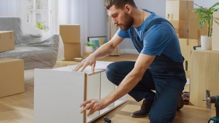 Furniture Assembly Worker Assembles Bookshelf. Professional Handyman Doing Assembly Job Well, Helping People who Move into New House.