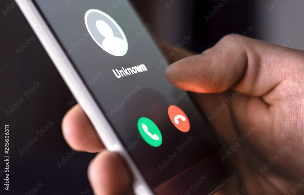 Phone call from unknown number late at night. Scam, fraud or phishing with smartphone concept. Prank caller, scammer or stranger. Man answering to incoming call. Hoax person with fake identity. - obrazy, fototapety, plakaty 