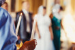 © Detkov D - The bride and groom holds waiting for wedding candle. Burn candle. Spiritual couple holding candles during wedding ceremony in christian church. close up