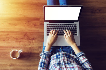 Wall Mural - top view of people typing on laptop computer with blank white screen from home on wooden floor with copy space