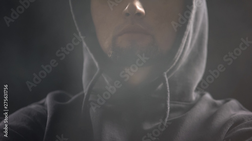 Man In Hoodie Sitting In Dark Room Full Of Smoke Anonymous