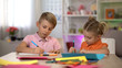 © motortion - Adorable boy and girl drawing with pencils, sitting at table, kindergarten