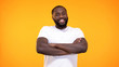 © motortion - Smiling black male folded arms looking camera bright background, positive mood