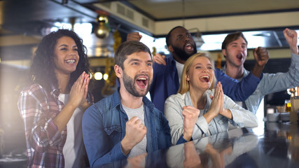 Wall Mural - Group of sport fans watching game in bar, rejoicing victory of favorite team