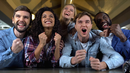 Wall Mural - Positive young people rooting for team goal, watching match together, audience