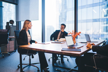 Executive male and female colleagues sitting at meeting table in conference room and spending time for planning productive strategy for business startup project, concept of entrepreneurship