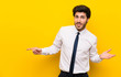 © luismolinero - Businessman on isolated yellow background pointing finger to the side and presenting a product