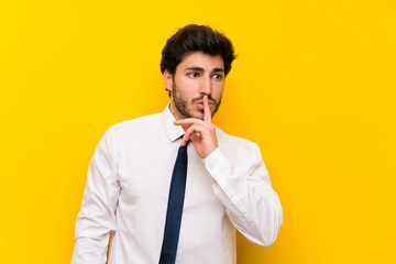 Businessman on isolated yellow background doing silence gesture