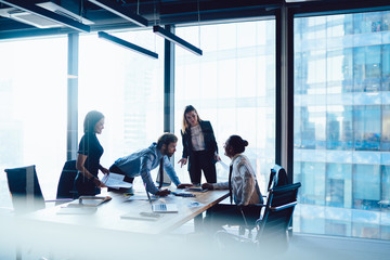 Crew of intelligent male and female having meeting table for discussing business startup ideas share opinions, brainstorming of clever professional employees teamworking at office interior