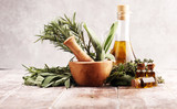 Fresh herbs from the garden and the different types of oils for massage and aromatherapy on table