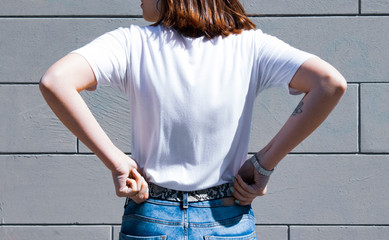 template and mockup blank white t-shirt and denim posing against gray street wall, for print store