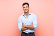 © luismolinero - Handsome man over pink background keeping the arms crossed in frontal position